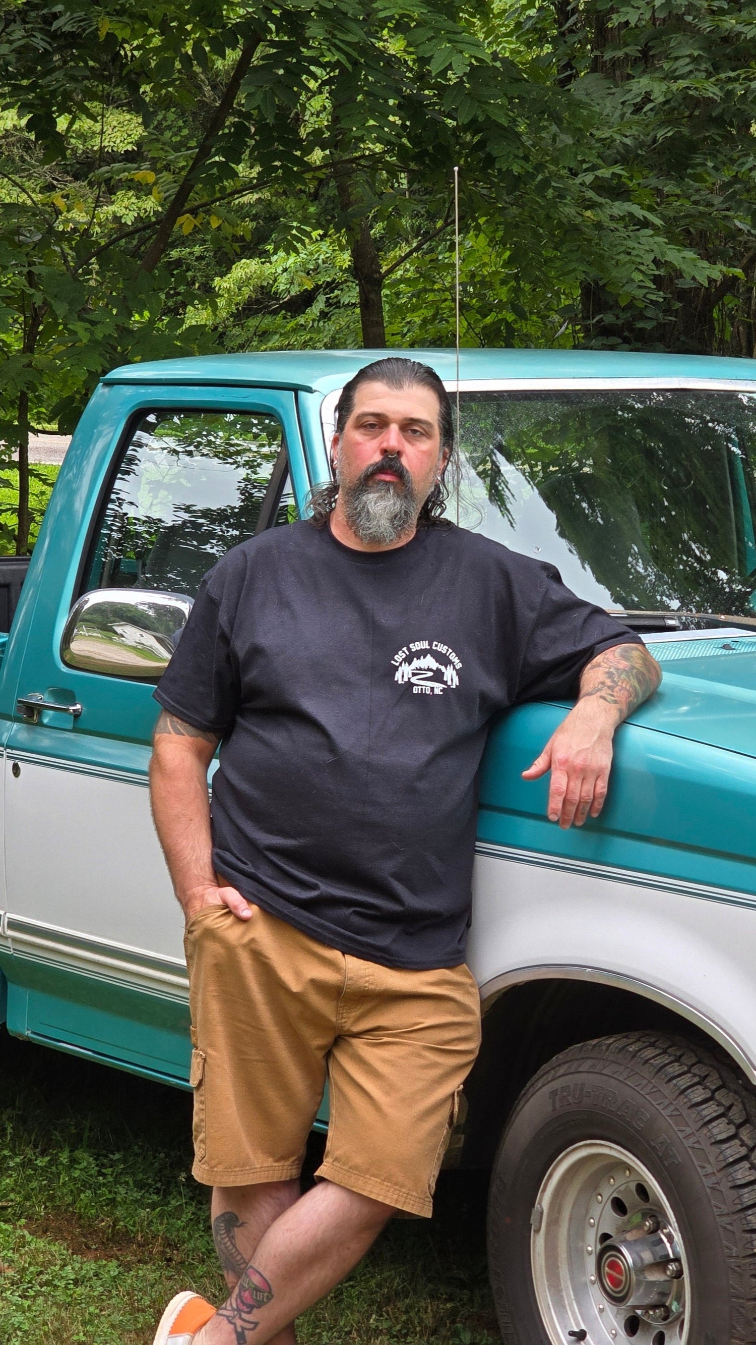 owner standing next to blue pickup truck